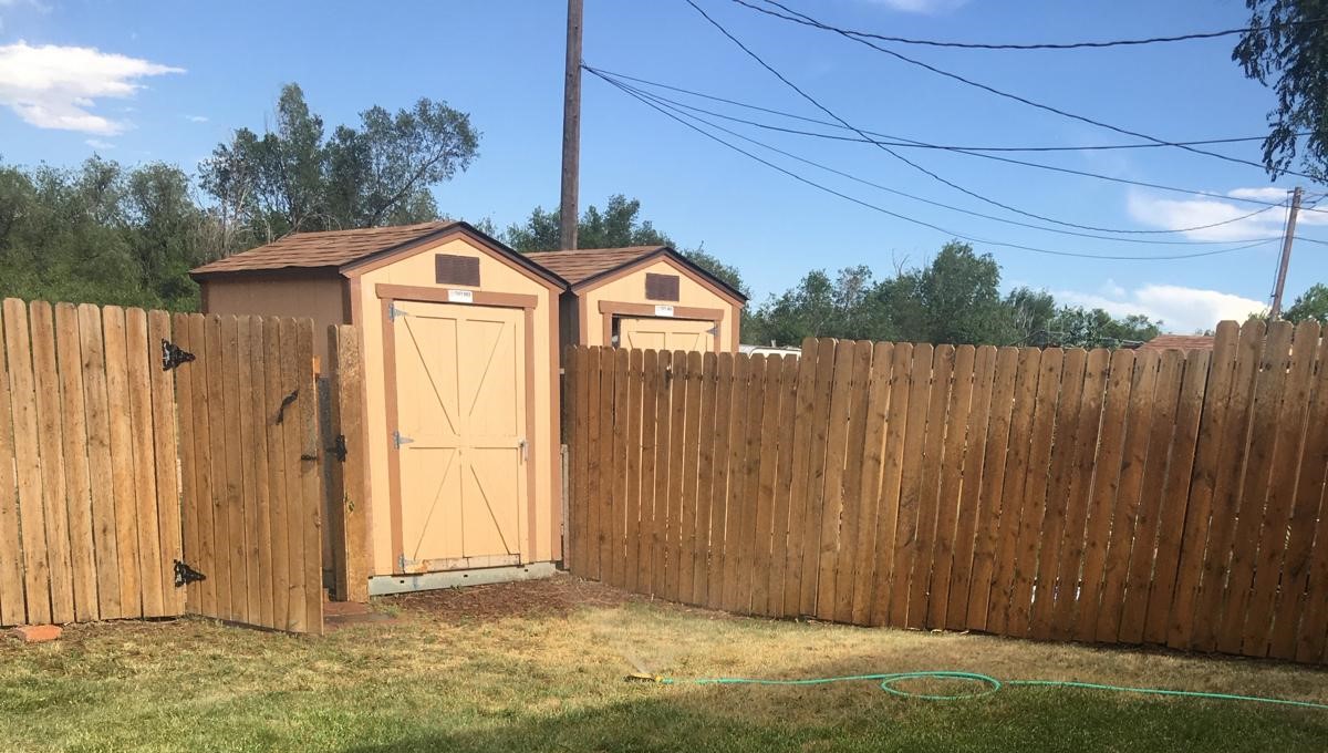 A backyard privacy fence with a gate.